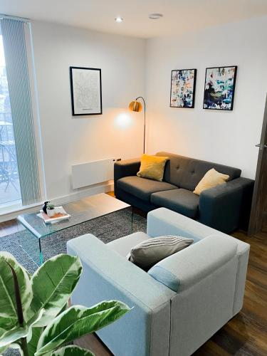 a living room with a couch and a table at The Panda - Modern 2 Bedroom Apt in Manchester City Centre in Manchester