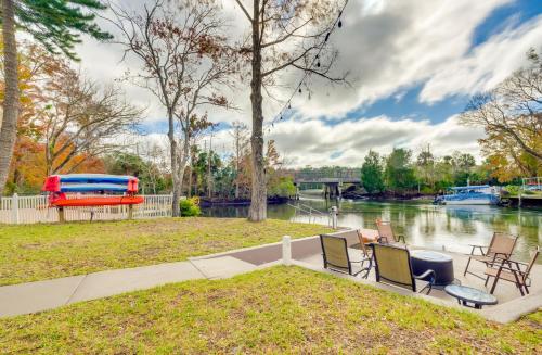 a patio with chairs and a boat on the water at Weeki Wachee River Home on Main River by Park! in Spring Hill
