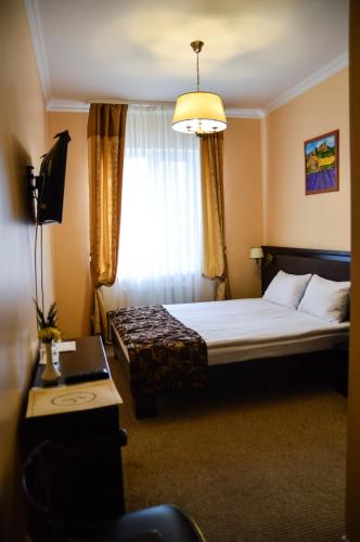 a hotel room with a bed and a window at Churchill-Inn in Vinnytsya