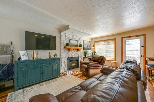 a living room with a leather couch and a television at Walk to Giant Steps Mtn Retreat with Hot Tub Access in Brian Head