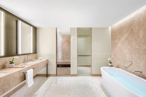 a bathroom with a tub and two sinks and a shower at Mandarin Oriental, Lago di Como in Blevio