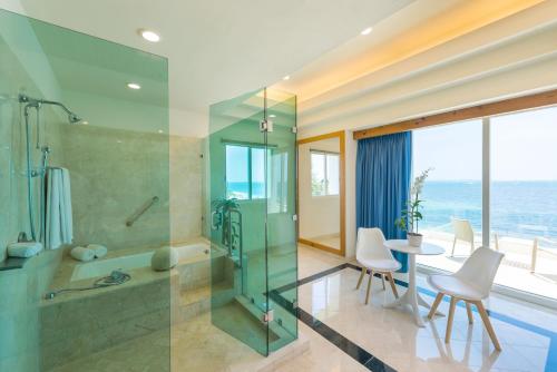 a bathroom with a shower and a table and chairs at Villa Punta Sam - Beachfront Luxury Villa in Cancún