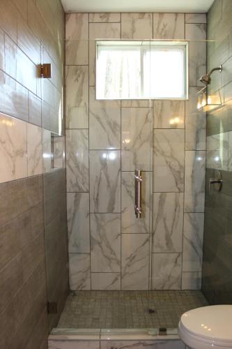 a bathroom with a shower with a glass door at Casa Maria Bonita in McDonough
