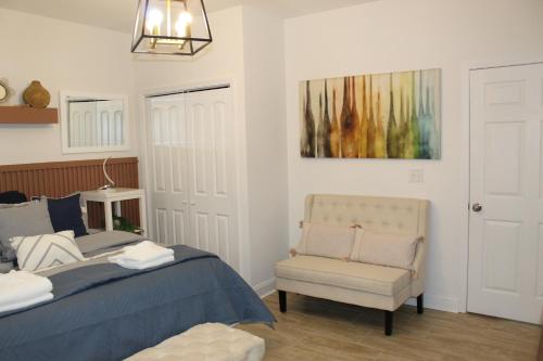 a bedroom with a bed and a chair and a painting at Casa Maria Bonita in McDonough