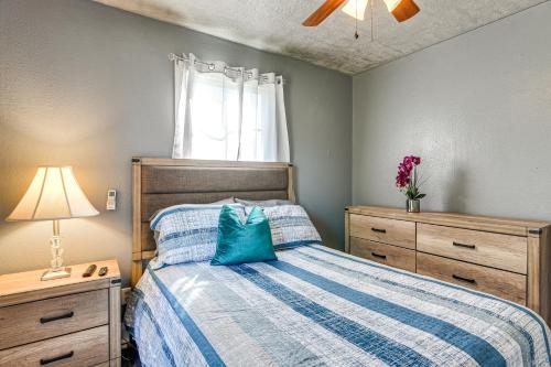 a bedroom with a bed with a blue comforter and a window at Near Sabine Lake Pet-Friendly Apt in Port Arthur in Port Arthur