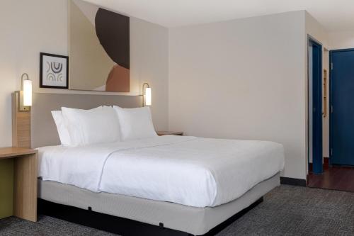 a large white bed in a hotel room at Spark By Hilton Evansville East, In in Evansville