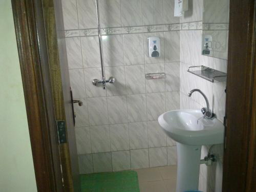 a bathroom with a sink and a shower at The Crested Crane Bwindi Hotel in Rugando