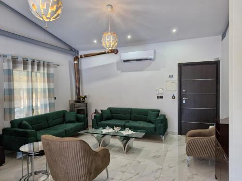 a living room with green couches and a table at Villa Elia in Aígio