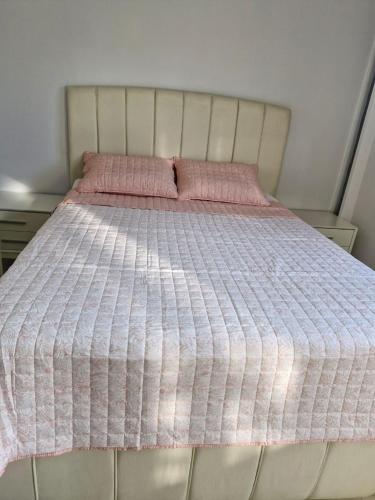 a bed with a pink and white blanket on it at Villa Elia in Aígio