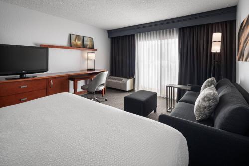 a hotel room with a bed and a desk at Courtyard by Marriott Pleasanton in Pleasanton