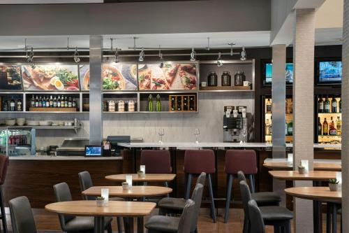 a restaurant with tables and chairs and a bar at Courtyard by Marriott Pleasanton in Pleasanton