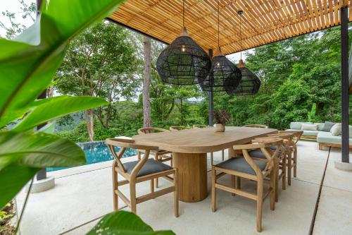 a wooden table and chairs on a patio at Villa Koa - Your Tropical Retreat in Santa Teresa Beach