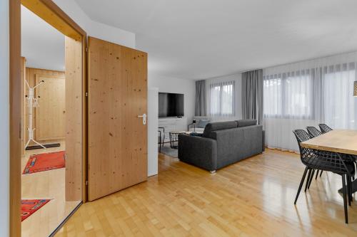 a living room with a couch and a table at Gemütliche 2.5 Zimmer Wohnung mit privater Sauna in Seewis im Prättigau