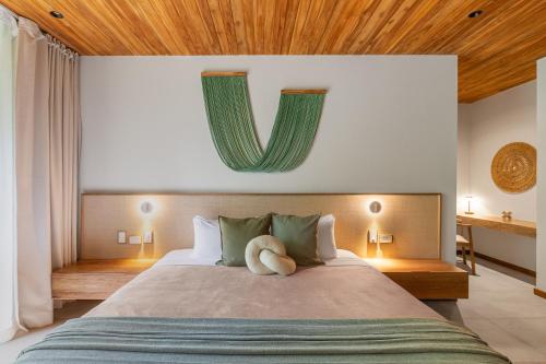 a bedroom with a large bed with a v on the wall at Villa Koa - Your Tropical Retreat in Santa Teresa Beach