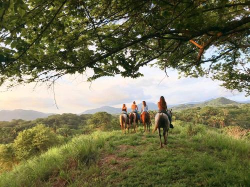 a group of people riding horses on a hill at Villa Koa - Your Tropical Retreat in Santa Teresa Beach