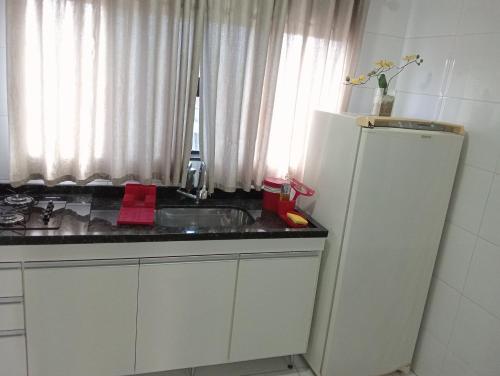 a kitchen with a white refrigerator and a sink at Casa do Henrique 2 in Sorocaba