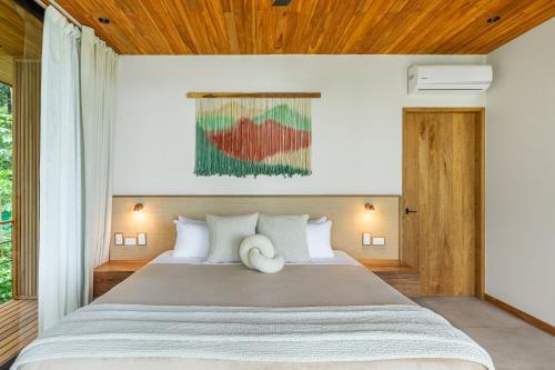 a bedroom with a large bed with a wooden ceiling at Villa Koa - Your Tropical Retreat in Santa Teresa Beach