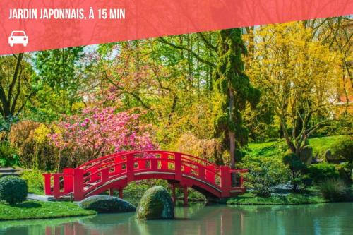 a red bridge over a pond in a garden at " Escale Balma " Entrée autonome - Linge fourni in Balma