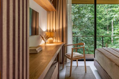 a bedroom with a desk with a chair and a window at Villa Koa - Your Tropical Retreat in Santa Teresa Beach
