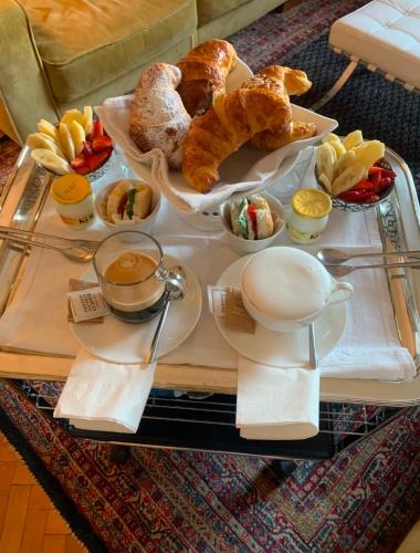 een dienblad met zoete deegwaren en croissants op een tafel bij Pattini Guest House in Milaan
