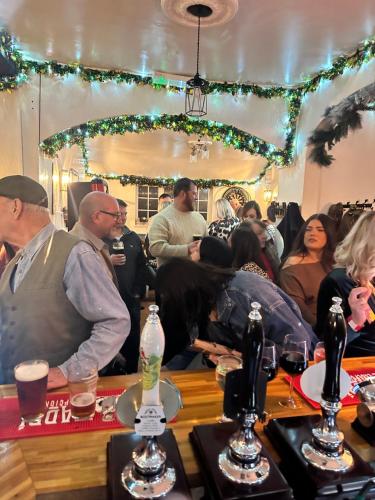 a group of people sitting at a bar at a party at The Fox Inn, Wilbarston in Wilbarston