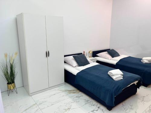 two beds in a room with white walls at LUMAX Studio in Gryfice