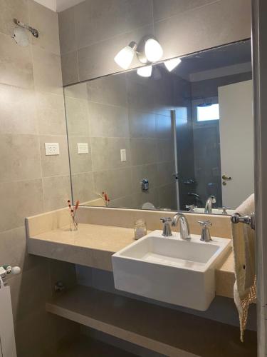 a bathroom with a sink and a large mirror at Departamento Capital San Juan in San Juan