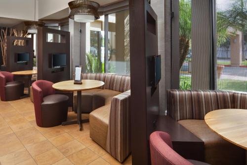 a restaurant with chairs and tables and windows at Courtyard Costa Mesa South Coast Metro in Santa Ana