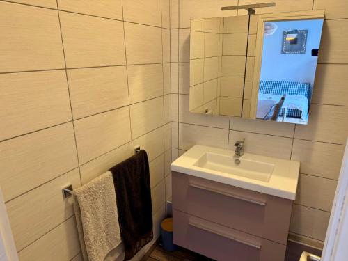 une salle de bain avec un lavabo et un miroir dans l'établissement T2 à 100M de Plage et Terrasse, à Les Sables-dʼOlonne