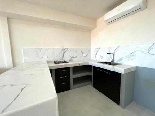a kitchen with marble counter tops and a sink at Beach Lofts and Surf in Jacó