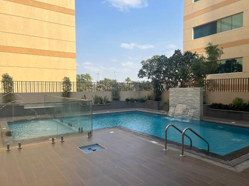 a swimming pool in front of a building at White Sage New Large 1BR at JVC in Dubai
