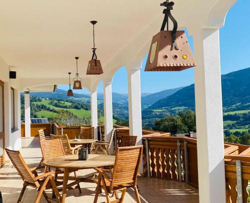 a patio with a table and chairs and mountains at Zlattinger in Trebesing