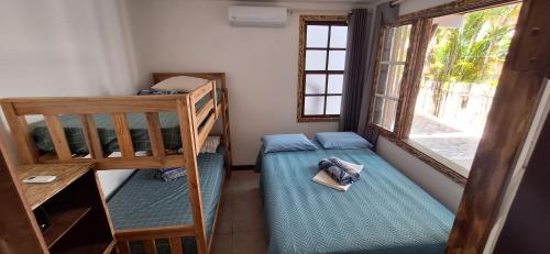 a room with two bunk beds and a window at CASA 2/4 PRAIA DO FORTE!!!! LOCALIZAÇÃO PRIVILEGIADA!!! in Praia do Forte