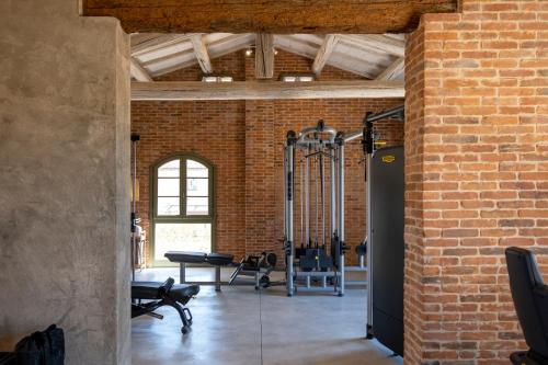 a room with a brick wall and a gym at Villa Petriolo - Small Luxury Hotels of the World in Cerreto Guidi