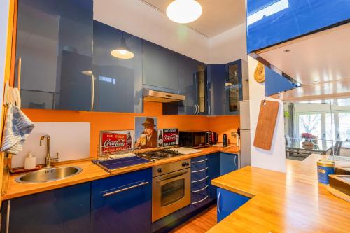 a kitchen with blue cabinets and a sink at Design apt "San Siro-Rho Fiera" Parking & Metro 100m in Milan