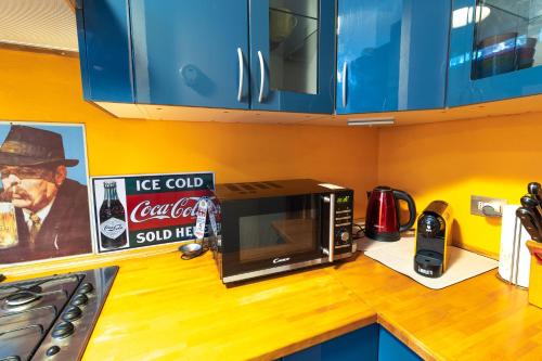 a kitchen counter with a microwave and a sign at Design apt "San Siro-Rho Fiera" Parking & Metro 100m in Milan