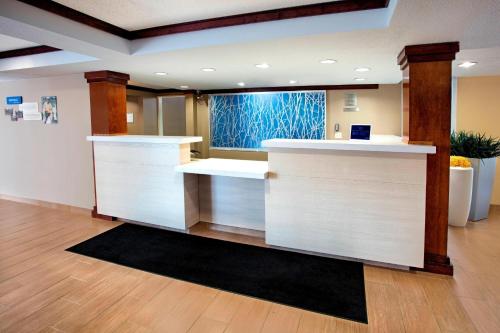 a lobby with a white counter with a window at Fairfield Inn & Suites Merrillville in Merrillville