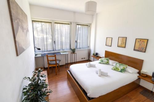 a bedroom with a large bed with white sheets at Design apt "San Siro-Rho Fiera" Parking & Metro 100m in Milan