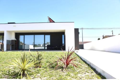 a white house with plants in the yard at Villa Casa Carlotti in Ponte de Vagos