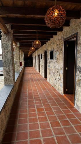 a walkway in a building with two chandeliers at La Peña Hotel Boutique & SPA in Cuetzalán del Progreso