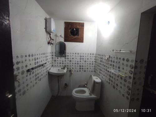 une salle de bain avec toilettes et lavabo dans l'établissement Brij Lok Dhaam 89792sham16956, à Mathura