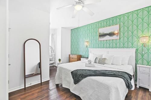 a bedroom with a white bed and a green wall at Large Pool, Near the Beach, 5 Bedroom, King Beds, Patio, Grill, Pet Friendly in Corpus Christi