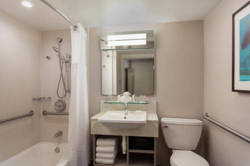 a bathroom with a sink and a toilet and a tub at Courtyard by Marriott Isla Verde Beach Resort in San Juan