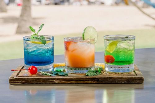 three cocktails on a wooden tray on a table at Courtyard by Marriott Isla Verde Beach Resort in San Juan