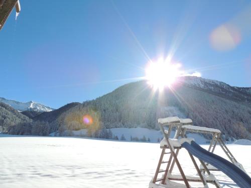 a ski lift in the snow with the sun at Residence Alpina in Santa Maddalena in Casies