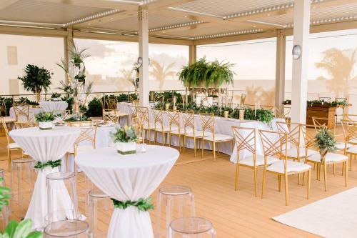 a banquet hall with tables and chairs with plants at Courtyard by Marriott Isla Verde Beach Resort in San Juan