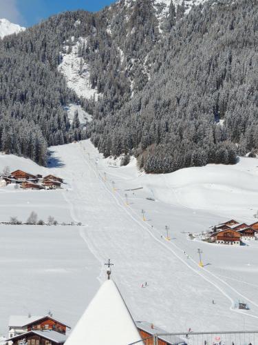 a ski slope in the middle of a snow covered mountain at Residence Alpina in Santa Maddalena in Casies