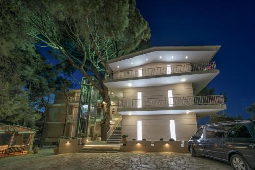 a house with a car parked in front of it at Koukounaria Hotel & Suites in Alykes