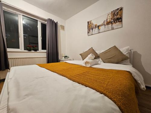 a bedroom with a large bed with a yellow blanket at London E14 Stay in London