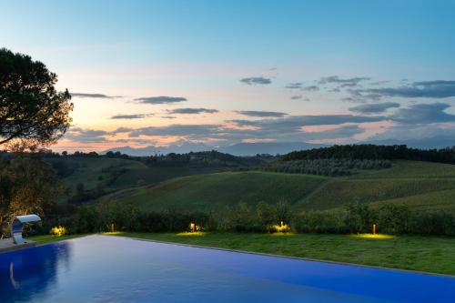 a swimming pool with a view of the hills at Villa Petriolo - Small Luxury Hotels of the World in Cerreto Guidi